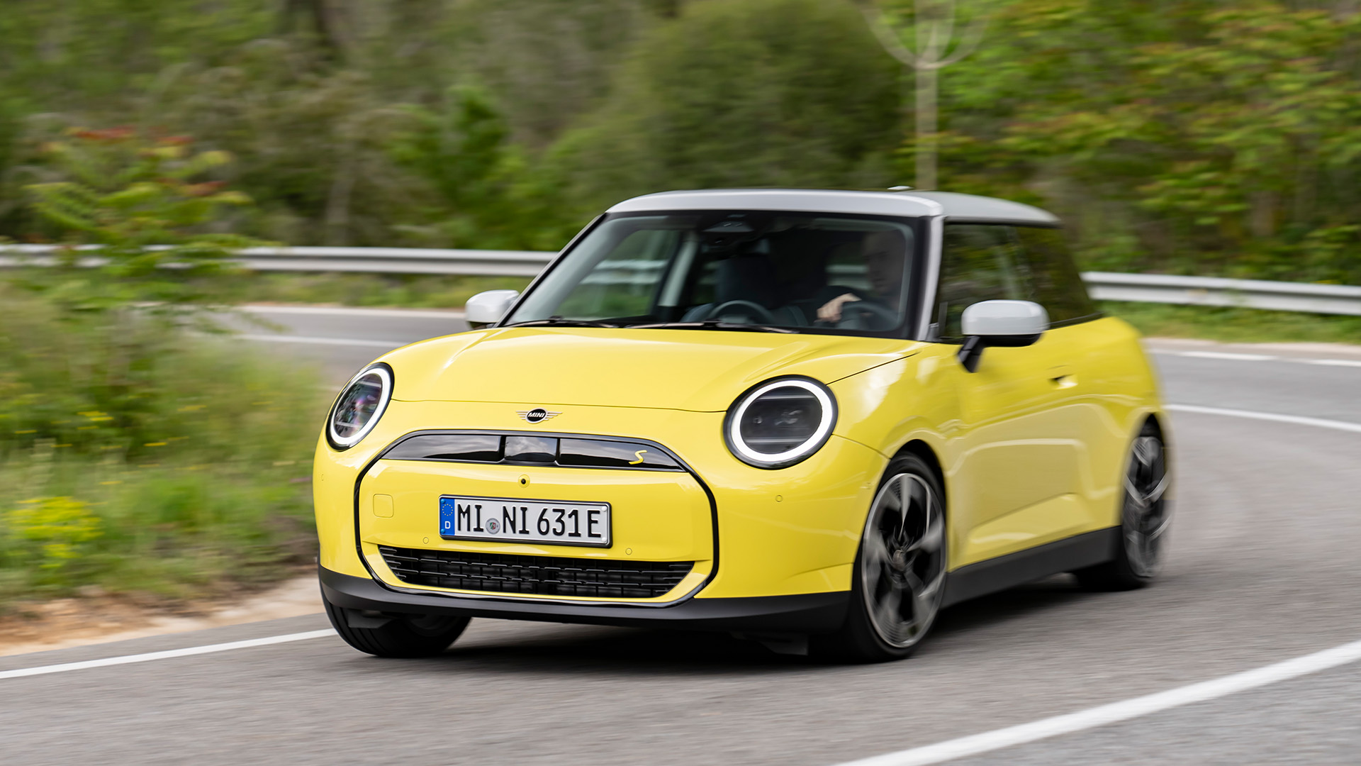 MINI Cooper in gelb bei Kurvenfahrt